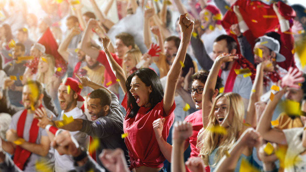 Fans at a stadium holding banners promoting sustainability and environmental action.