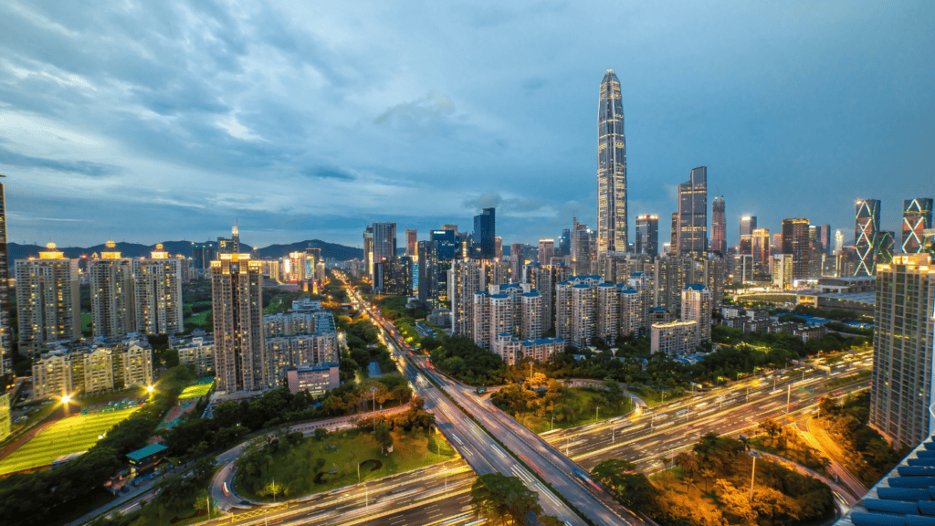 A cityscape shows the contrast between pollution and clear skies, symbolizing the impact of carbon emissions on urban environments.