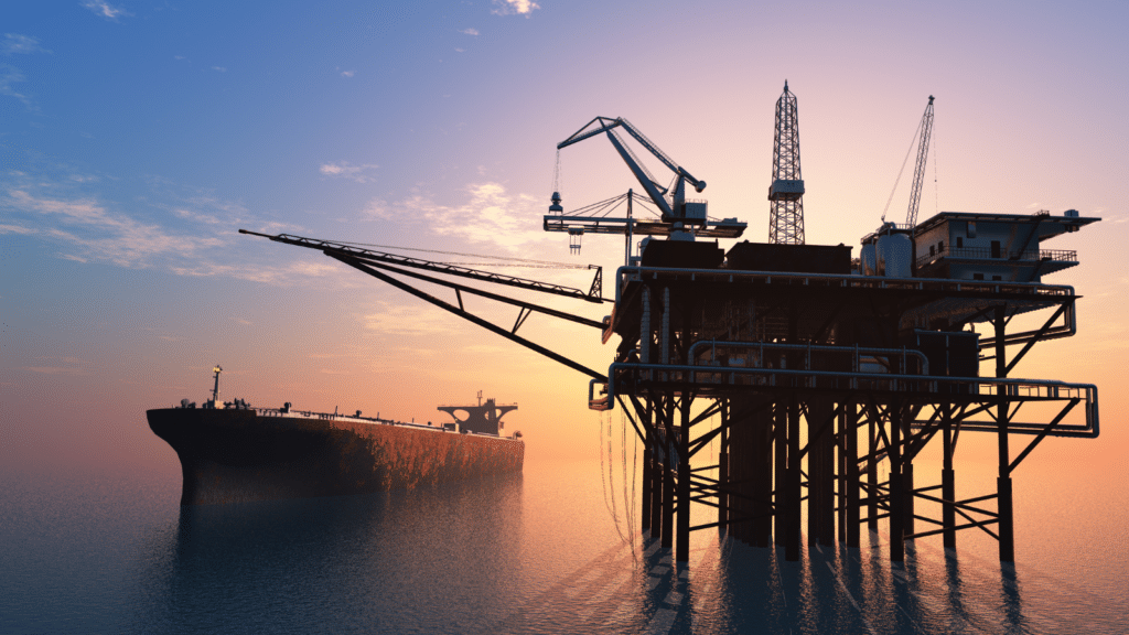 Offshore oil rig with a tanker ship in the background during sunset, illustrating the fossil fuel debate at COP29.